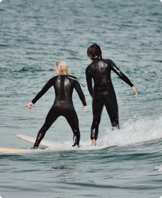 Two people surfing on the water, representative of the water and power sports industry