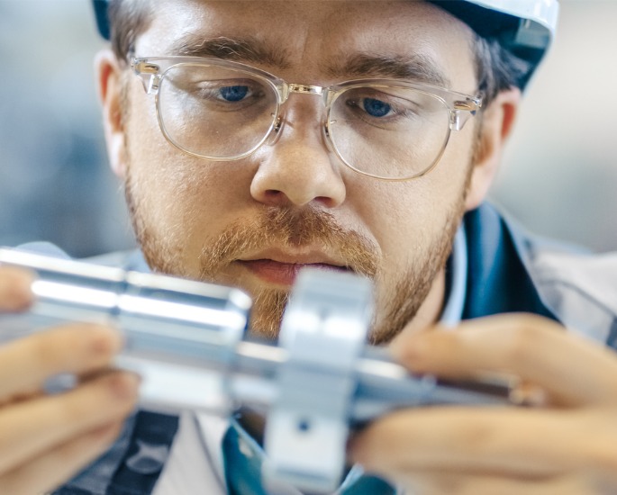 A professional engineer inspecting the quality of a newly created part, part of the testing services offered by DMi