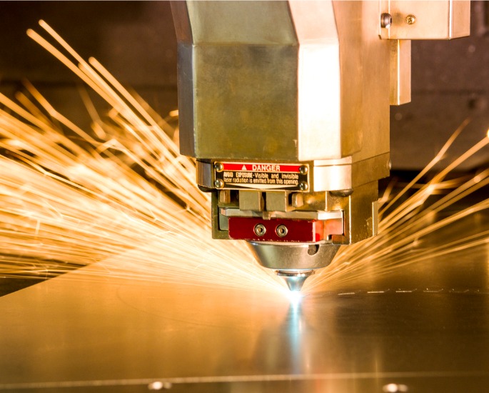 Laser cutting a metal sheet, part of the fabrication work offered by DMi